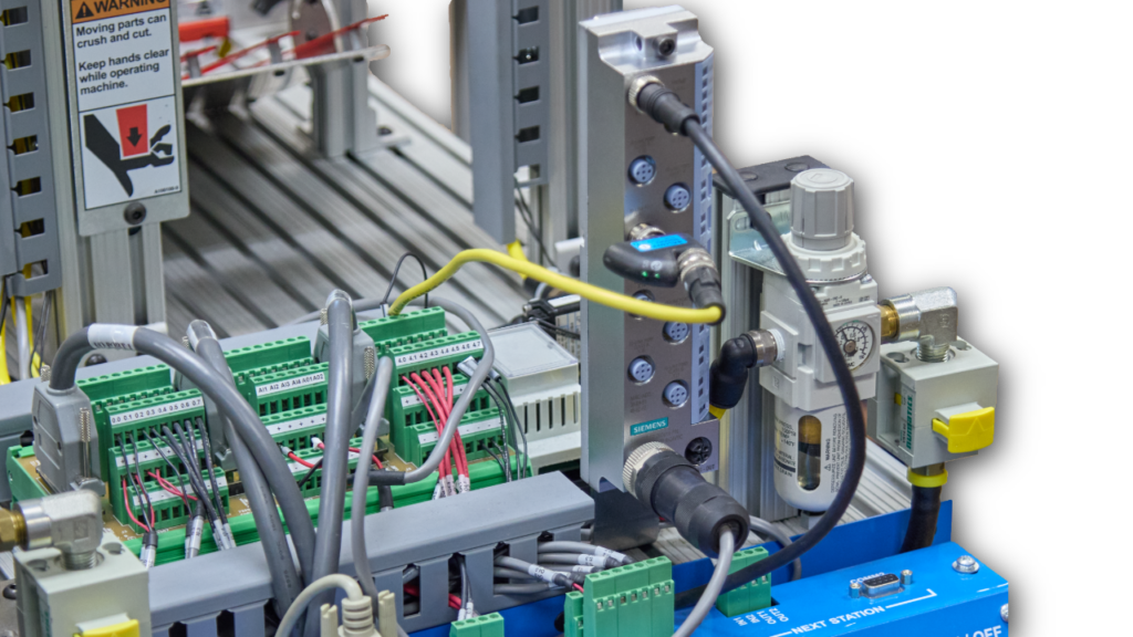 Industrial control panel with wiring, green terminal blocks, and a pneumatic regulator on the right side.