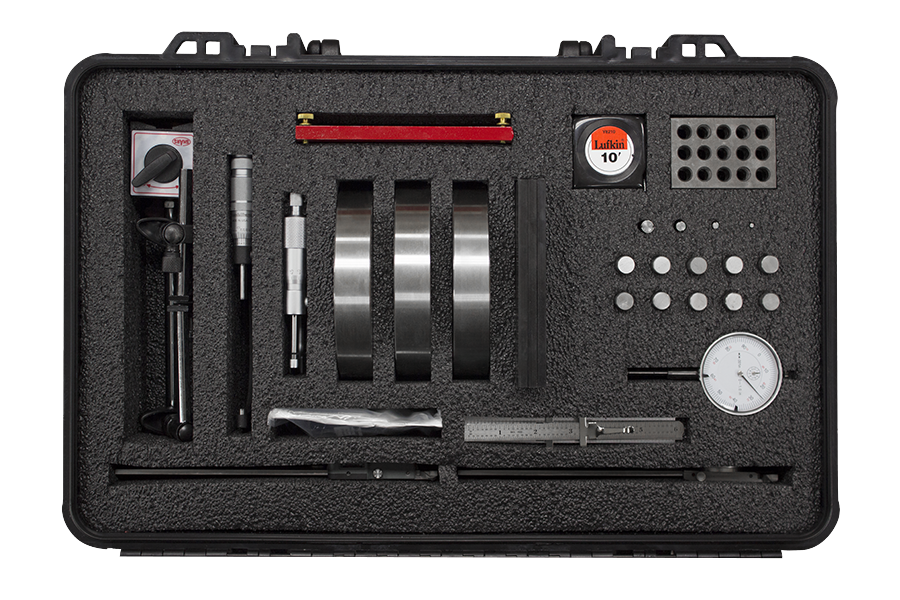 A black foam-lined toolkit with assorted precision tools, including calipers, a dial gauge, tapes, meters, and small measurement discs for mechanical setup and calibration.