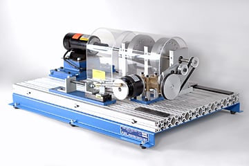 Industrial lab test rig with a transparent protective cover mounted on a blue metal frame and roller components.