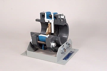 Compact bench-top mechanical clamp assembly with blue spacers mounted on a metal base plate.