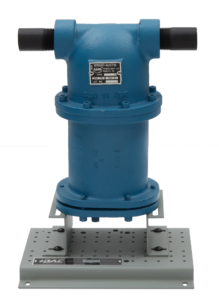 Blue industrial valve actuator mounted on a perforated metal base on a workbench, with a label visible on the device.