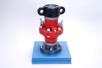 Pressure relief valve mounted on a blue base with a red body, black bonnet, and bolted connections.