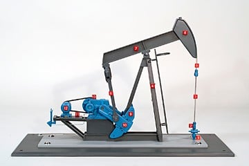 Scale model of an oil pump jack with blue gear housing on a metal base, featuring numbered indicators along the beam and rod for labeling.
