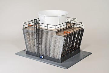 Industrial outdoor HVAC condenser unit with protective metal cage, finned coils, and a white intake cover, mounted on a metal base with a blue valve at the bottom.