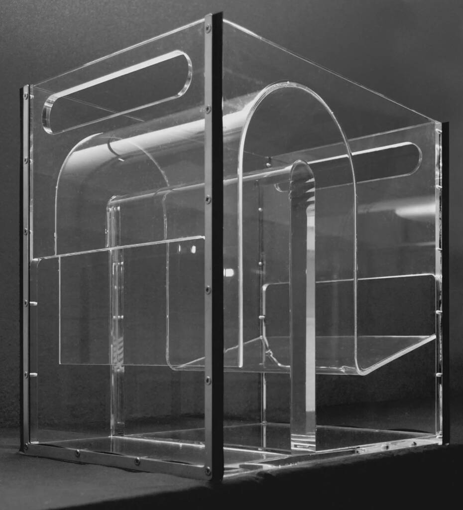 Clear glass display case with metal framing and visible screws, set against a dark background.