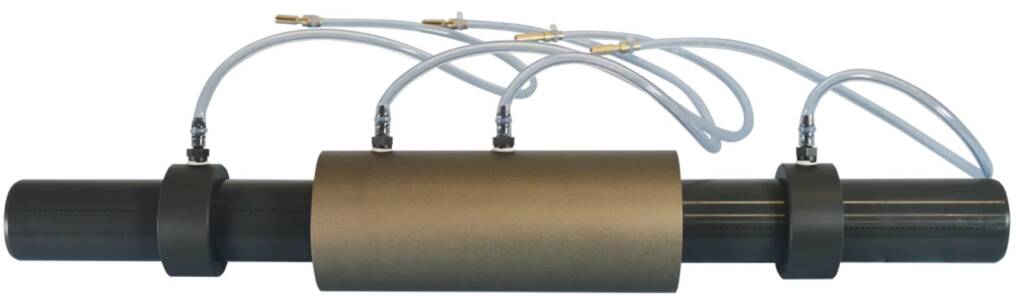 Inline clamp-on sensor with tubing attached to a black pipe, featuring a large central brown protective sleeve and two pipe clamps