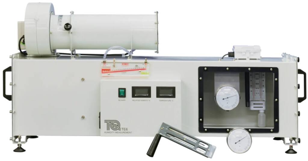 Humidity measurement system with a control panel, two digital meters, and a large white cylindrical component mounted on top.