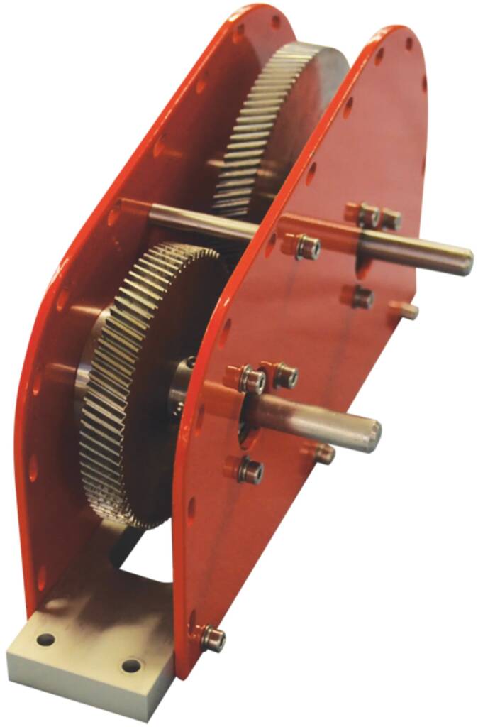 Red gearbox housing with interlocking gears and a horizontal output shaft protruding from the side, mounted on a base plate.