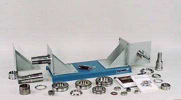 Assortment of precision ball bearings, seals, rollers, and shafts laid out on a blue display plate for inspection or display purposes.
