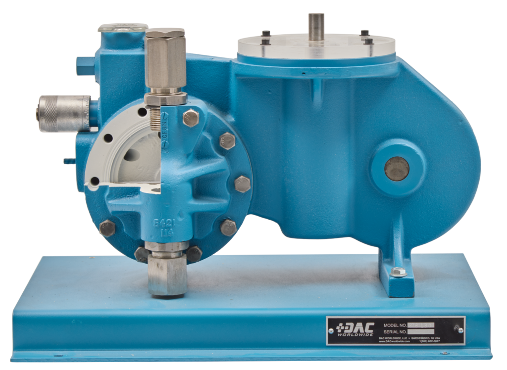 Blue industrial pump mounted on a blue base with metal fittings and a label on the right side plate (training equipment).