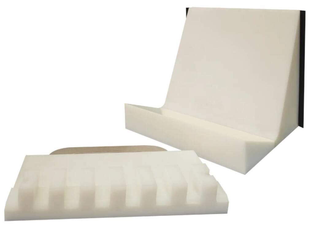 White foam packaging pieces: a large rectangular block with a grid texture, a curved sleeve, and a tall angled box on a white background.